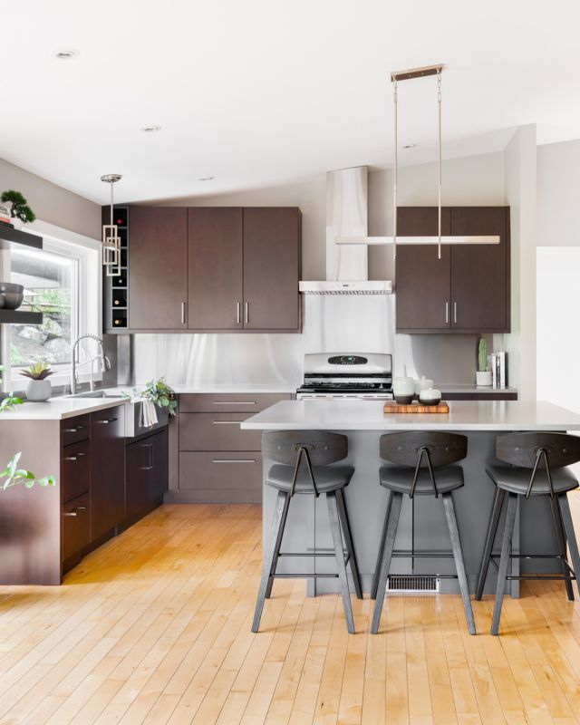 The stainless steel backsplash and cherry wood cabinets complement each other in this modern kitchen. 

Cabinetry: Chablis Dusk on Cherry, New Haven door style
Designer: Alexandra Graham
Dealer: @thomasandbirchboutique
Photographer: @dashaaphotos