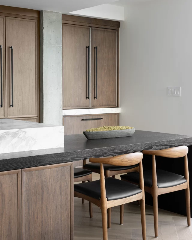 With sleek cabinetry, minimalist hardware, and a harmonious blend of light and dark wood tones, this space is a perfect example of understated elegance. The marble accents add a touch of luxury, creating an inviting atmosphere for both cooking and dining. 

#ElmwoodCabinetry #Elmwood #cabinetry #cabinets #customkitchen